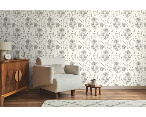 Salon avec papier peint à motifs, fauteuil et commode en bois