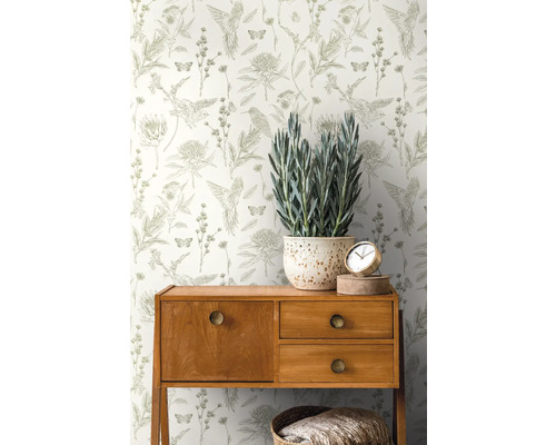 Tapete mit Blumen-, Vogel- und Schmetterlingsmuster hinter Kommode und Topfpflanze