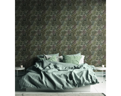 Chambre avec un lit et un mur avec du papier peint à motifs de feuilles