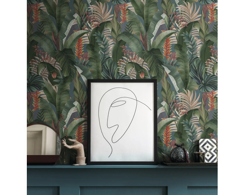 Scène avec papier peint à motifs avec des feuilles tropicales, une image encadrée et des objets décoratifs sur une étagère