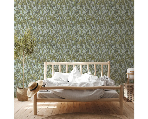 Schlafzimmer mit Bett vor einer botanischen Tapete mit Blättern