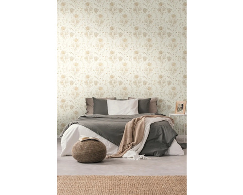 Chambre avec papier peint floral et lit double.