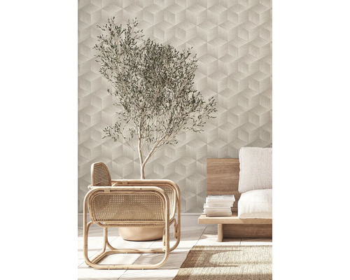 Wohnraum mit geometrischer Tapete, Rattansesseln und Olivenbaum