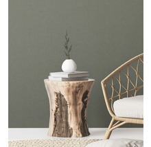 Scène décorative avec un tabouret en bois, des livres, un vase et un fauteuil en rotin pour une ambiance élégante.
