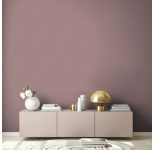 Salon avec commode, lampe et décoration devant un mur