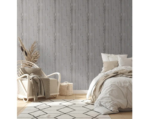 Dekoratives Schlafzimmer mit grauer Holzoptik Tapete, Sessel und Bett