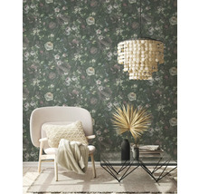 Salon avec papier peint à motifs floraux, fauteuil, table basse et suspension
