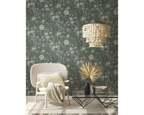 Salon avec papier peint à motifs floraux, fauteuil, table basse et suspension