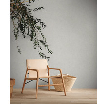 Scène avec fauteuil, panier et décoration sur plancher en bois devant un mur