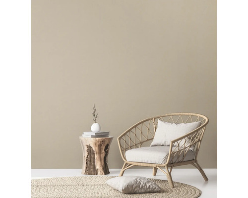 Dekoratives Wohnzimmer mit Rattansessel, Beistelltisch aus Holz und rundem Teppich