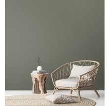 Salon avec fauteuil en rotin, table d''appoint en bois et tapis rond