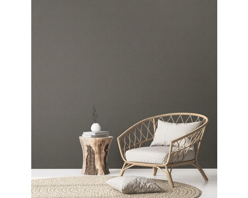 Dekorative Szene mit Rattan Sessel, Holzhocker, Teppich und Kissen für eine gemütliche Atmosphäre