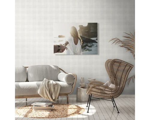 Wohnzimmer mit Sofa, Stuhl und Wandbild mit Strandmotiv