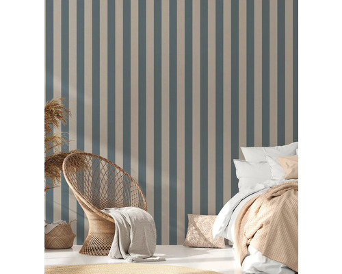 Schlafzimmer mit gestreifter Tapete, Rattansessel und Bett