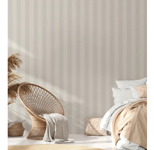 Chambre avec papier peint rayé, fauteuil en rotin et lit