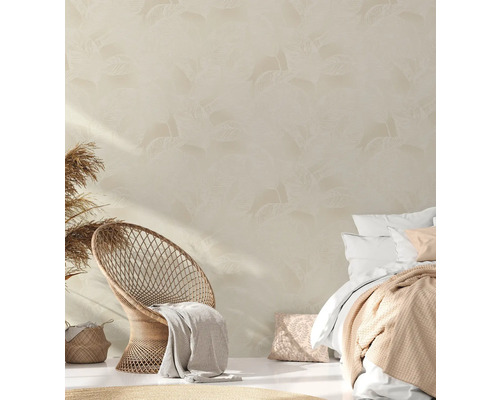 Schlafzimmer mit Rattansessel, Bett und Tapete mit Blattmuster