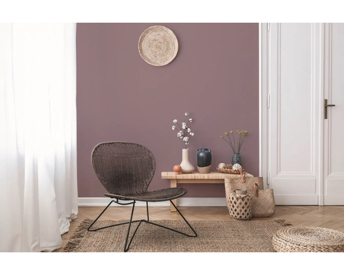 Salon avec fauteuil en rotin, table en bois et décorations sur un tapis