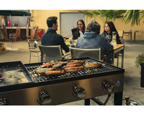 Scène de barbecue avec des saucisses, des légumes et des personnes en arrière-plan