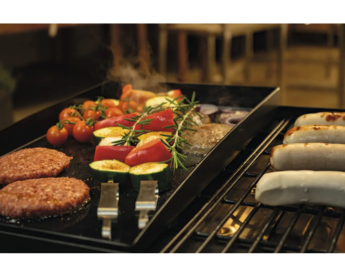 Gemüse, Burger und Würstchen auf einem Grill.