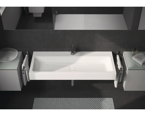 Modernes Badezimmer mit rechteckigem Waschbecken, Armaturen und Ablageflächen.