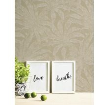 Papier peint à motif de plantes, images encadrées et décoration sur une table