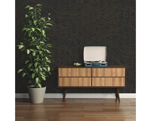 Intérieur décoratif avec plante, tourne-disque et commode devant un papier peint structuré.