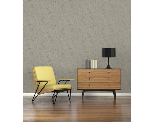 Wohnzimmer mit Sessel, Kommode und gemusterter Tapete