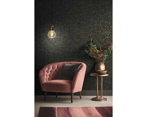 Salon avec fauteuil, coussin, table d''appoint, lampe et papier peint à motifs.