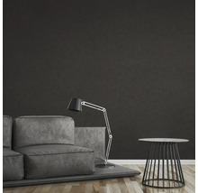 Séjour avec canapé, lampadaire et table d''appoint devant un mur sombre