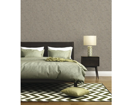 Schlafzimmer mit Bett, Nachttischlampe, Teppich und gemusterter Tapete