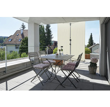 Balcon avec table de jardin, chaises, parasol et éléments décoratifs