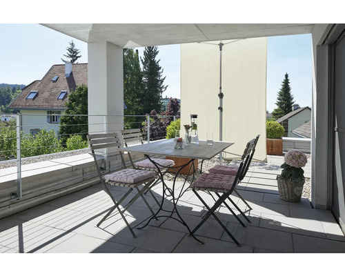 Balcon avec table de jardin, chaises, parasol et éléments décoratifs