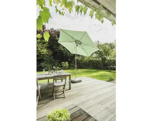 Gartenszene mit Sonnenschirm, Tisch und Stühlen auf einer Terrasse