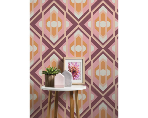 Vue d''une pièce avec papier peint géométrique, table d''appoint, plante en pot et cadre photo