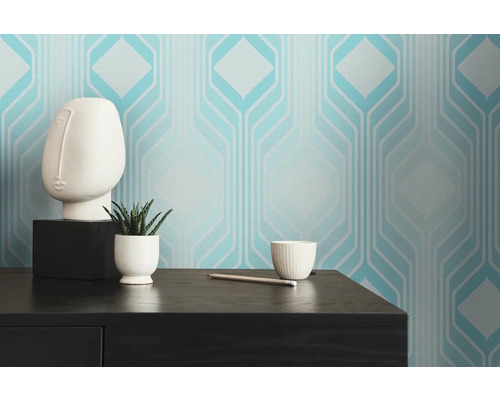 Pièce avec papier peint géométrique, plante et décoration sur une table