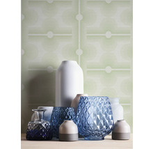 Arrangement de différents vases devant un papier peint à motifs