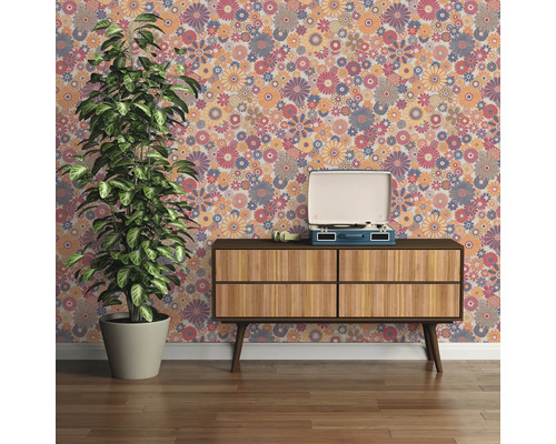 Pièce décorative avec papier peint à fleurs, tourne-disque sur une armoire en bois et plante en pot.