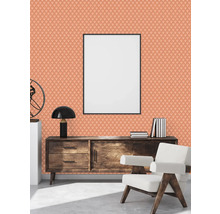 Salon avec papier peint à motifs, commode et fauteuil
