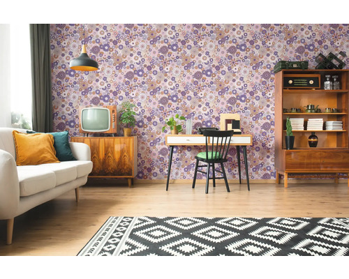 Salon avec papier peint à motifs floraux, canapé, tapis et meubles de style rétro.