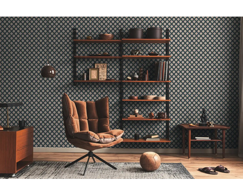 Wohnzimmer mit gemusterter Tapete, Regalen, Sessel, Teppich und Holzboden.