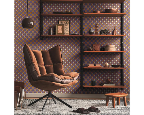 Salon avec fauteuil à oreilles, étagère et papier peint à motifs pour une atmosphère chaleureuse