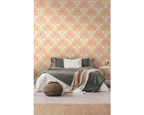 Une chambre avec un lit et du papier peint à motifs.