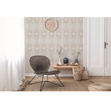Intérieur avec papier peint géométrique, fauteuil en rotin et objets décoratifs