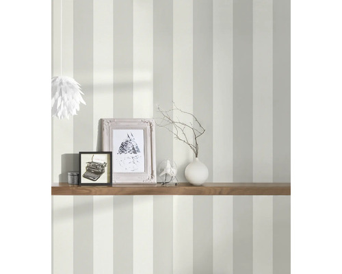 Gestalteter Raum mit gestreifter Tapete, Regal, Bilderrahmen und Dekoration