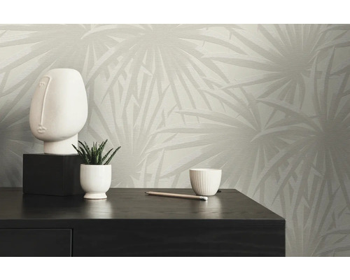 Moderne Zimmerdekoration mit gemusterter Tapete, dekorativer Skulptur und Zimmerpflanze auf einem dunklen Holzschrank