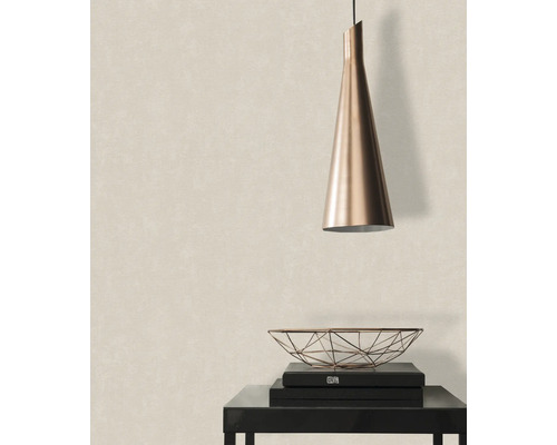 Scène avec suspension, coupe décorative et livres sur une table devant un papier peint