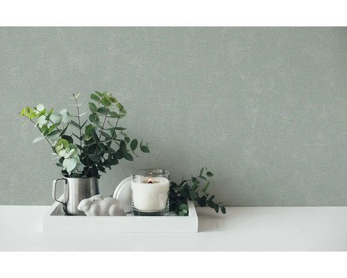 Scène décorative avec eucalyptus, bougie et décoration sur un plateau devant un mur