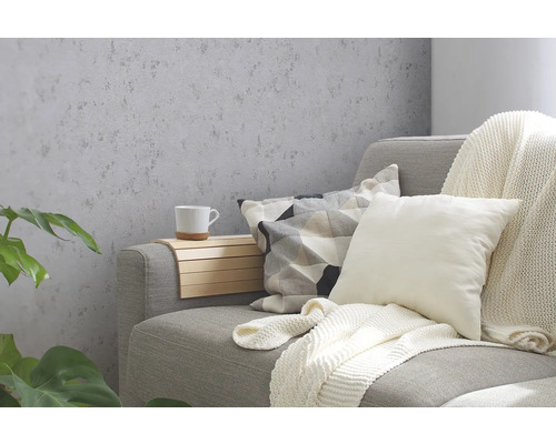 Wohnzimmer mit grauer Strukturtapete, Sofa, Kissen und Dekorationen.