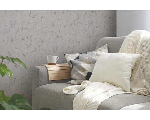 Salon décoratif avec papier peint à motifs, canapé, coussins et plantes