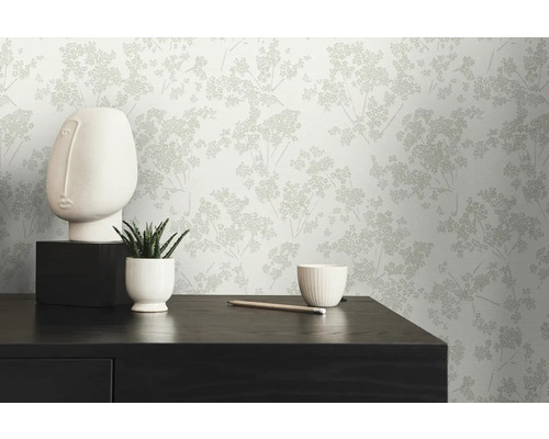 Intérieur décoratif avec un papier peint à motifs, une sculpture et une plante d''intérieur sur une commode.